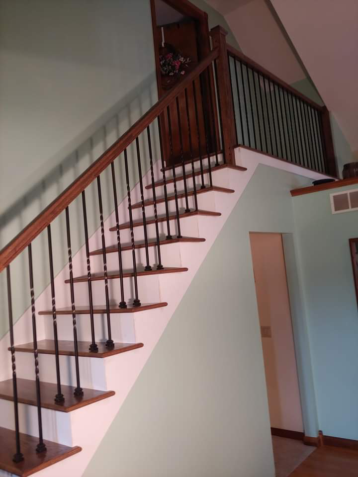 Wood staircase with dark metal balusters